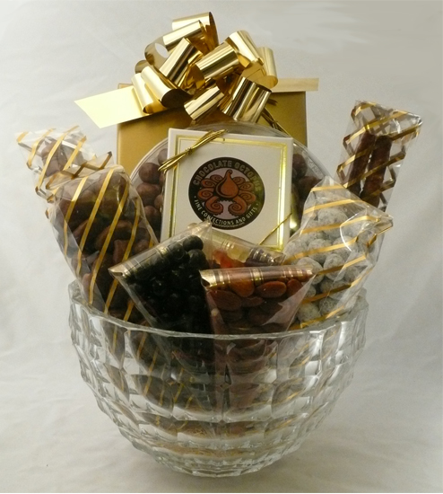 Mikasa Crystal Bowl with Confections  - A beautiful Mauritius Crystal Lead Bowl by Mikasa is filled with a twelve-piece assortment of our Signature Chocolates in our signature box.  A large round container of chocolate covered caramel corn, a large bag of snowy praline pecans and a large bag of chocolate covered amaretto pecans.  Two pretzel rods dipped in caramel and chocolate, a 4 piece box of octopus bark, and three small containers of almonds, gummy bears and dark chocolate covered coffee beans. Shrink wrapped with a decorative bow. 